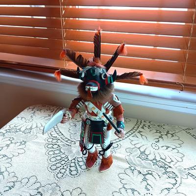KACHINA DOLL HAND CARVED & PAINTED W/FUR & FEATHERS WIELDING A HAND SAW
