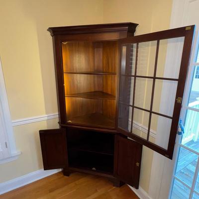 Sale Photo Thumbnail #80: Henkel Harris Cherry Corner Cabinet. Glass door, right hinged. Excellent overall condition. Interior vertical lighting added.  Key included. 
6’-3”H x 3’-2”W x 21”D