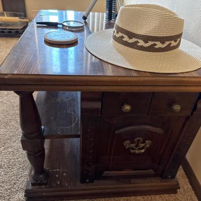 Side table, flashlight, magnifying glass, coaster, and a hat