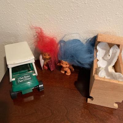 Small trolls, wooden cradle and golf cart