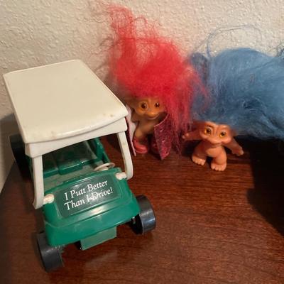 Small trolls, wooden cradle and golf cart