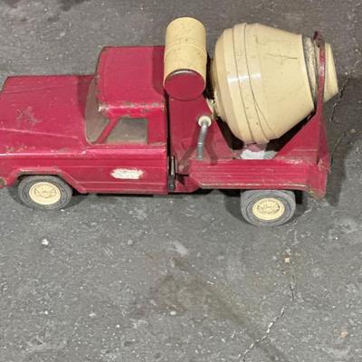 3 plastic sleds and a vintage concrete truck toy.
