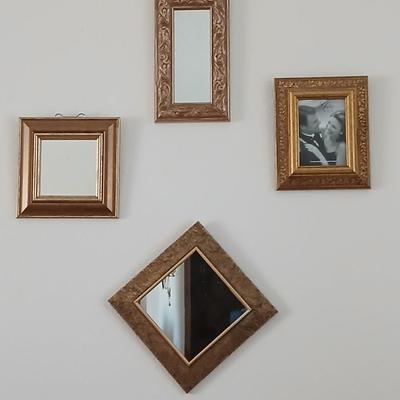 Grouping of mirrored wall hangings and a picture frame