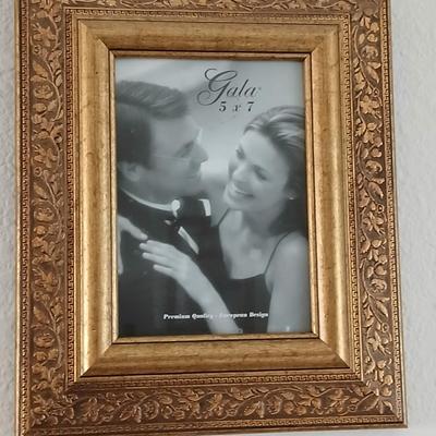 Grouping of mirrored wall hangings and a picture frame
