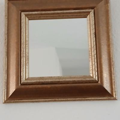 Grouping of mirrored wall hangings and a picture frame