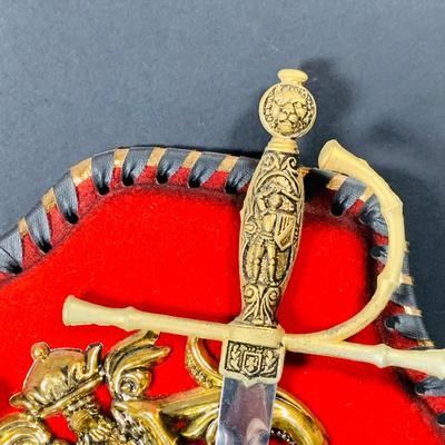 LOT:53: Medieval Coat of Arms, Don Quixote Metal Statue and Metal Ashtray, Miniature Alter Cross, Mini Brass Mortar and Pestle and a Thimble