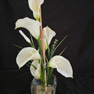 Faux cala lilies in a vase with four floral wall hanging plaques