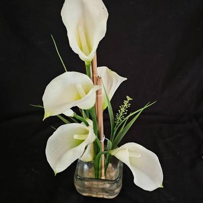 Faux cala lilies in a vase with four floral wall hanging plaques