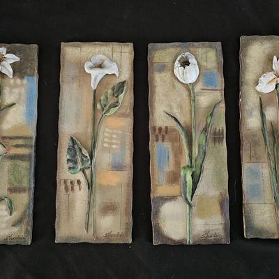 Faux cala lilies in a vase with four floral wall hanging plaques