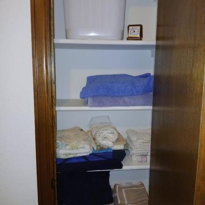 Bath towels, hand towels, bath trash can and a travel alarm clock