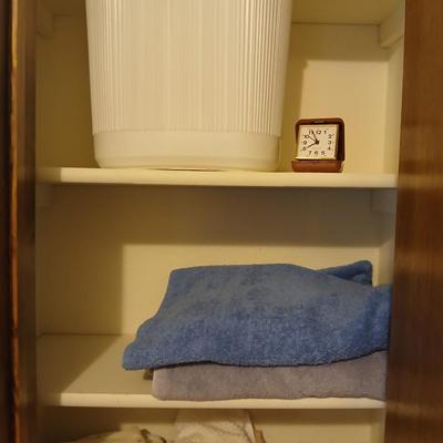 Bath towels, hand towels, bath trash can and a travel alarm clock
