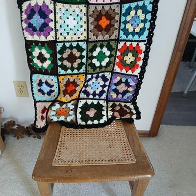 Vintage wicker seat dining room chair and an Afghan shawl