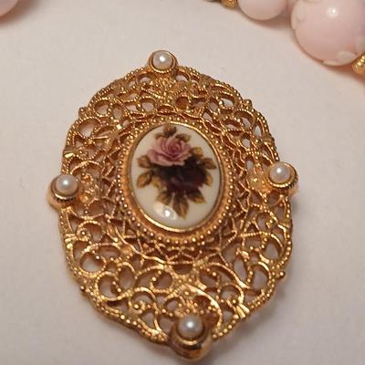 Two fashion necklaces with brooches and earrings