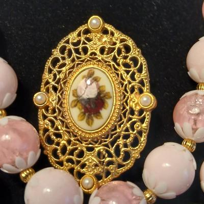 Two fashion necklaces with brooches and earrings