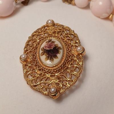 Two fashion necklaces with brooches and earrings