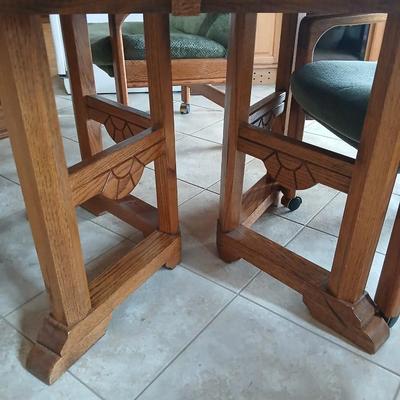 Oak Kitchen table with leaf and four upholstered chairs on casters