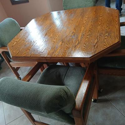 Oak Kitchen table with leaf and four upholstered chairs on casters