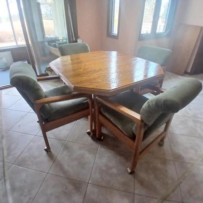 Oak Kitchen table with leaf and four upholstered chairs on casters