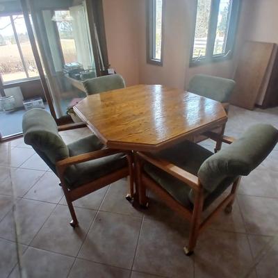 Oak Kitchen table with leaf and four upholstered chairs on casters