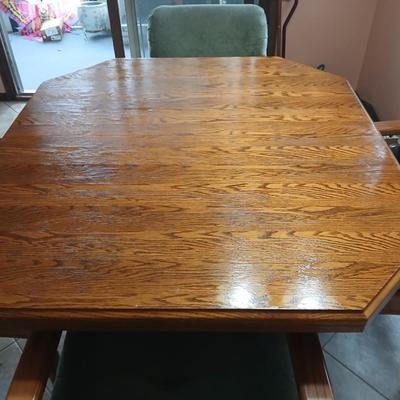 Oak Kitchen table with leaf and four upholstered chairs on casters