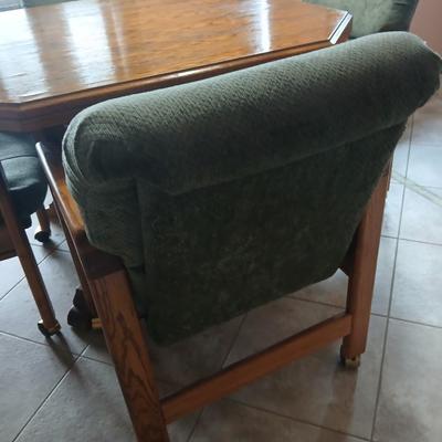 Oak Kitchen table with leaf and four upholstered chairs on casters