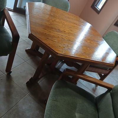 Oak Kitchen table with leaf and four upholstered chairs on casters