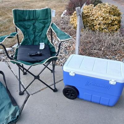 Folding camping chair with clean Igloo cooler on wheels