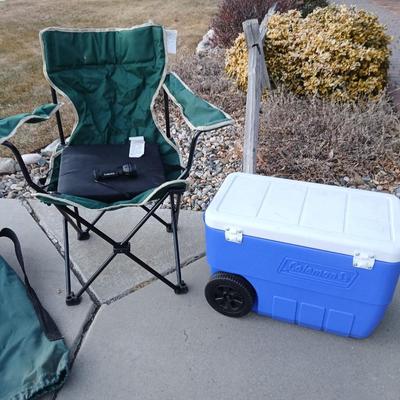Folding camping chair with clean Igloo cooler on wheels