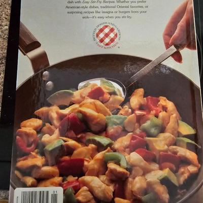 Large stew pot with lid, smaller pot with lid, utensils, and cookbooks