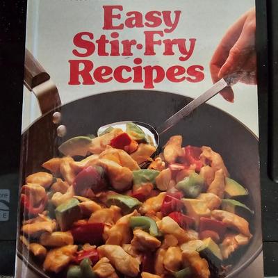 Large stew pot with lid, smaller pot with lid, utensils, and cookbooks