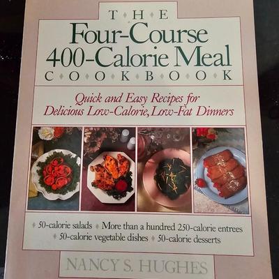 Large stew pot with lid, smaller pot with lid, utensils, and cookbooks