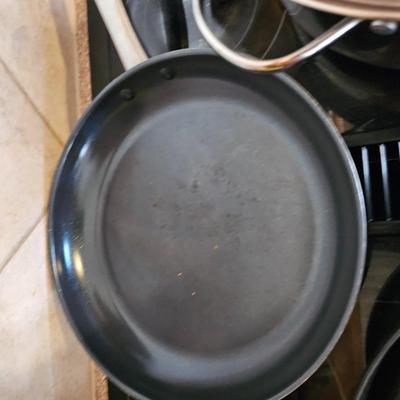 Large stew pot with lid, smaller pot with lid, utensils, and cookbooks