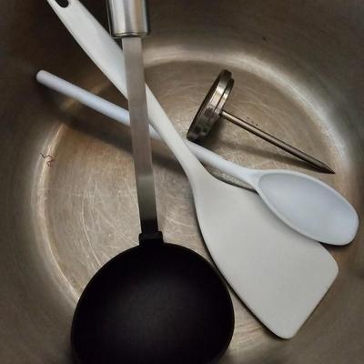 Large stew pot with lid, smaller pot with lid, utensils, and cookbooks