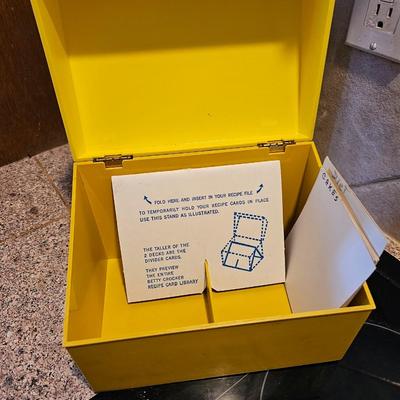 Collection of cookbooks and a large yellow recipe box