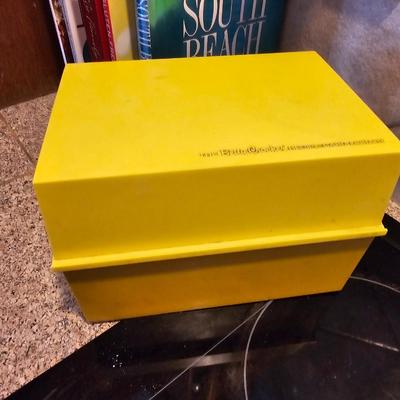 Collection of cookbooks and a large yellow recipe box