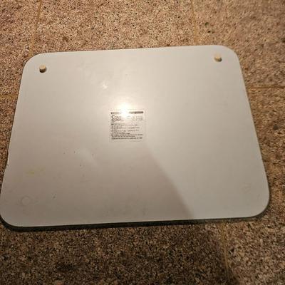 Two corning casserole dishes with lids and a Corning counter cutting board