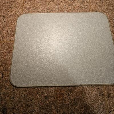 Two corning casserole dishes with lids and a Corning counter cutting board