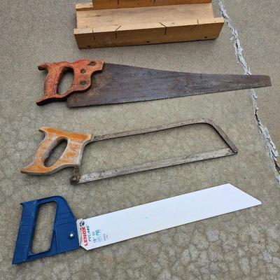 Assortment of hand saws with a wooden Mitre box
