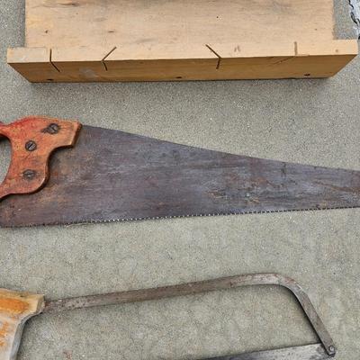 Assortment of hand saws with a wooden Mitre box