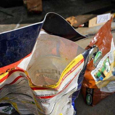 Variety of flowerpots, and partial bags of lawn car and fertilizer
