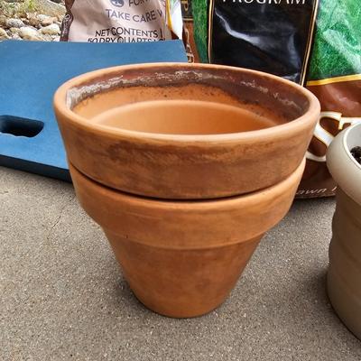 Variety of flowerpots, and partial bags of lawn car and fertilizer
