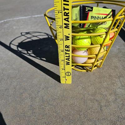 Colored Golf balls in smaller heavy metal golf ball range basket with a golf ball grabber