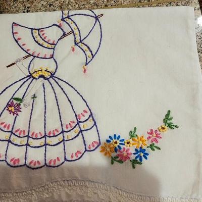Vintage embroidered kitchen linens and a Royal eight-inch expandable trivet