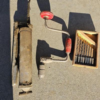 Vintage wood handled drill with drill bits and an old grease gun