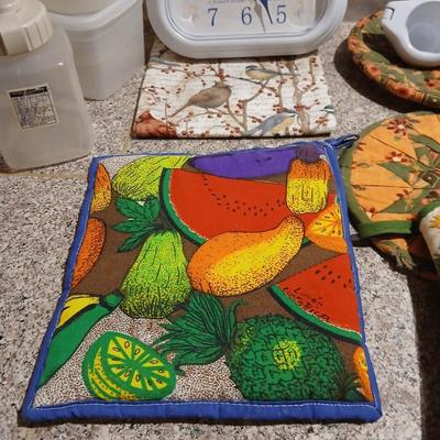 Assortment of Kitchen items - Hot pads - wall clock - plastic food storage and more