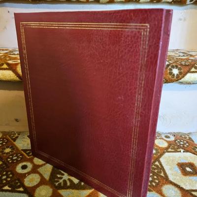 Assortment of framed artwork, picture frames, and photo album books