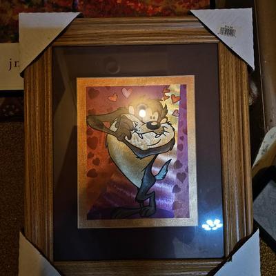 Assortment of framed artwork, picture frames, and photo album books