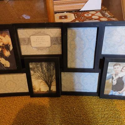 Assortment of framed artwork, picture frames, and photo album books