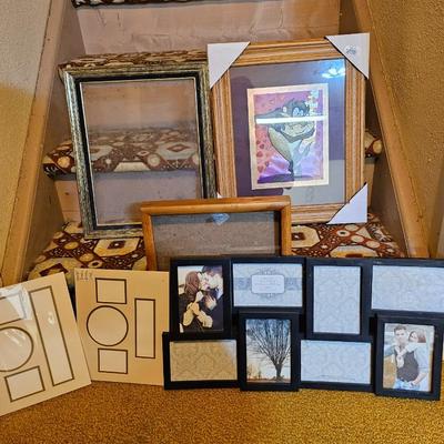 Assortment of framed artwork, picture frames, and photo album books