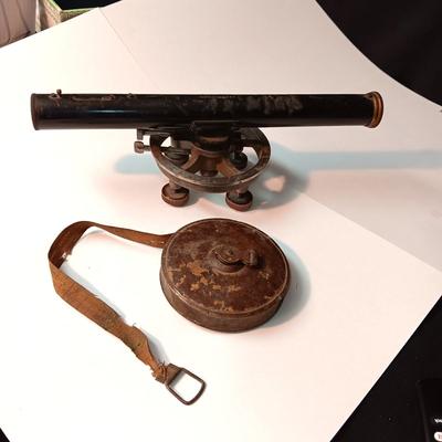 VINTAGE SURVEYORS TRANSIT LEVEL AND AN ANTIQUE TAPE MEASURE